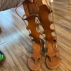 Mid calf stretch laced sandal with gold detail and zipper back closure